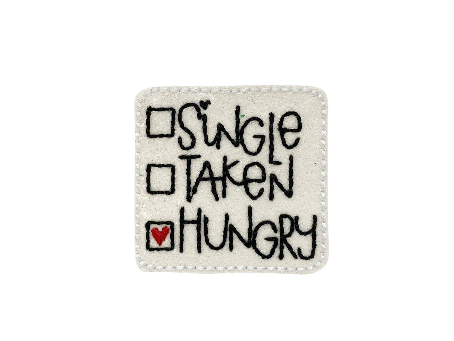 Sparkly square Valentine’s Day dog collar embellishment with the phrase "Single, Taken, Hungry", attached by an elastic loop.