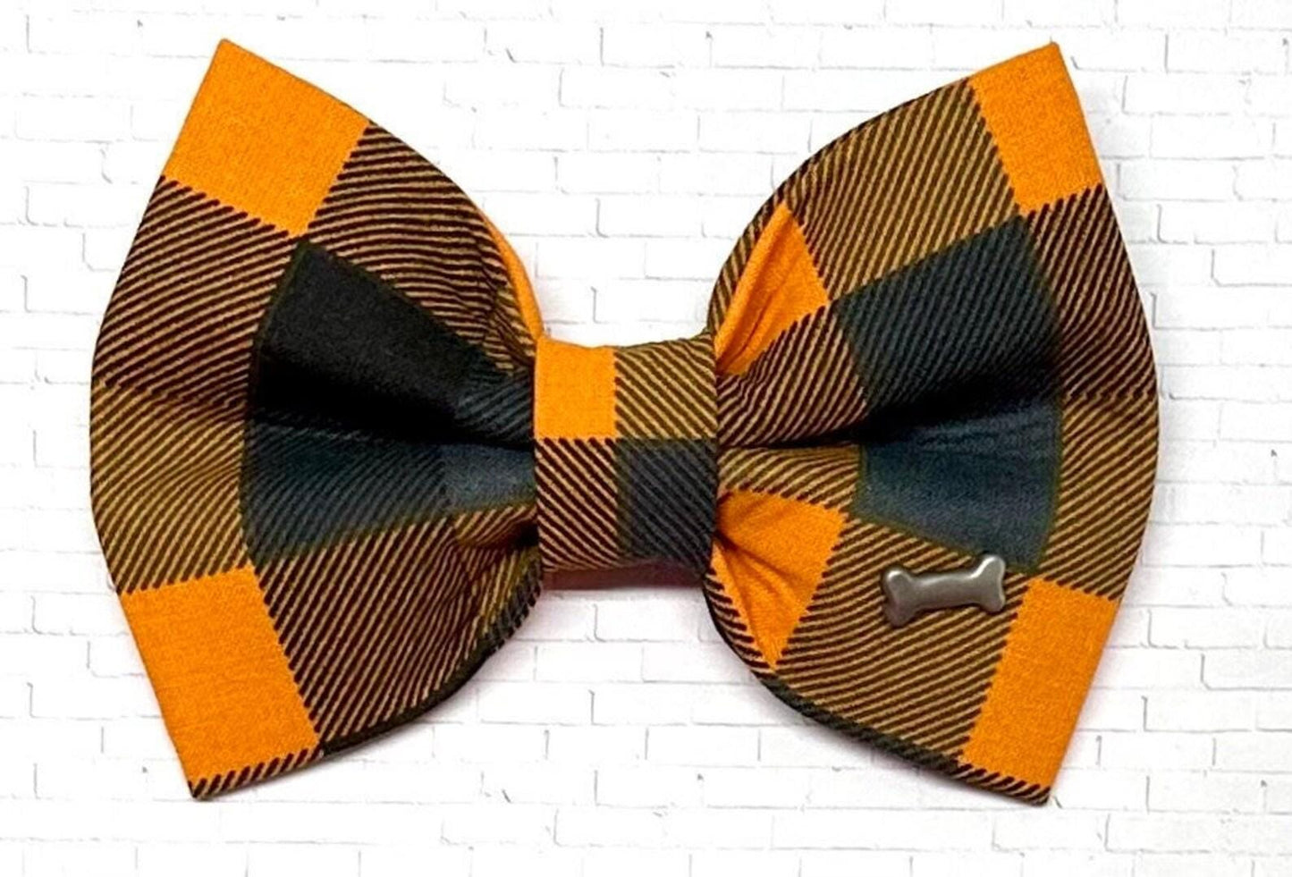A black and orange Halloween checkered bow tie for dogs placed on a white background.
