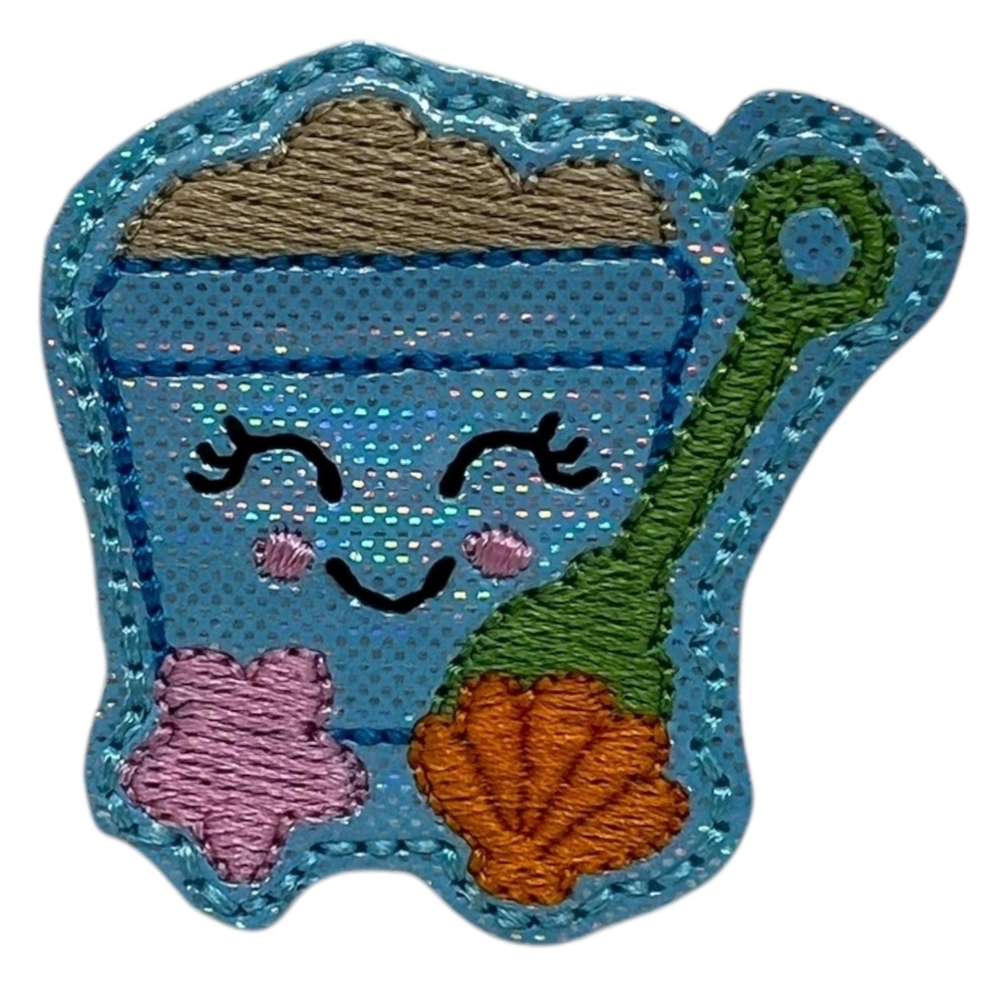 Close-up of a blue sand bucket dog collar embellishment, featuring a shimmery pail design with tiny shovel and sea shell details, perfect for adding a fun beachy touch to your pup’s summer outfit.