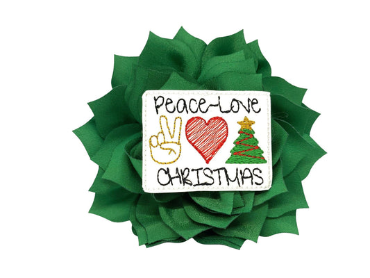 Emerald Green dog collar flower with layered petals and a “Peace, Love & Christmas” embellishment in the center, shown in a 4-inch flower.