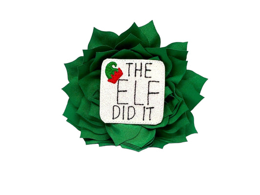 Emerald green dog collar flower with sparkly “The Elf Did It” Christmas embellishment, layered petals, and elastic loop for easy collar attachment.