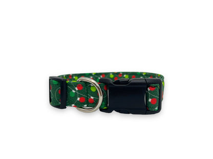 Green dog collar decorated with red and green Christmas lights, displayed on a white background. The festive design adds cheerful holiday flair, perfect for winter walks and celebrations.