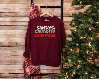 Maroon “Santa’s Favorite Dog Mom” sweatshirt with festive red and green holiday lettering, cozy unisex fit, and perfect for Christmas-loving dog moms.