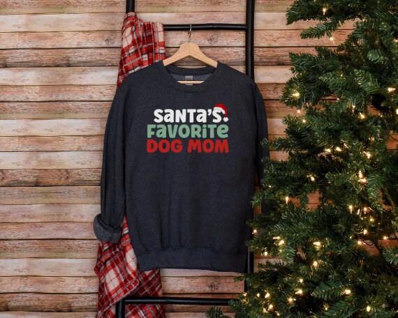 Gray “Santa’s Favorite Dog Mom” sweatshirt with festive red and green holiday lettering, cozy unisex fit, and perfect for Christmas-loving dog moms.