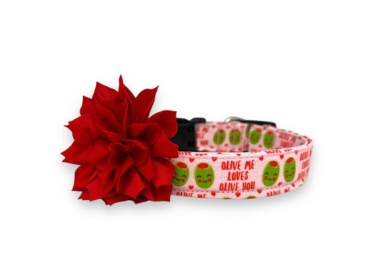 Light pink Valentine’s Day dog collar with heart-shaped olive pattern, “Olive Me, Loves Olive You” text, and removable red flower embellishment.