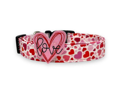 Valentine’s Day dog collar with red and pink heart pattern and removable red and pink heart embellishment reading “love”