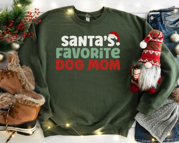 Green “Santa’s Favorite Dog Mom” sweatshirt with festive red and green holiday lettering, cozy unisex fit, and perfect for Christmas-loving dog moms.