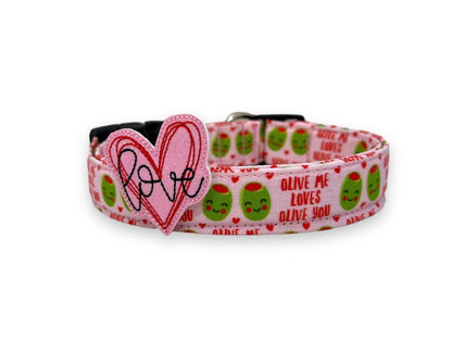 Light pink Valentine’s Day dog collar with heart olive design and “Olive Me, Loves Olive You” text. Includes removable pink heart with the word "love" in it embellishment for festive style.