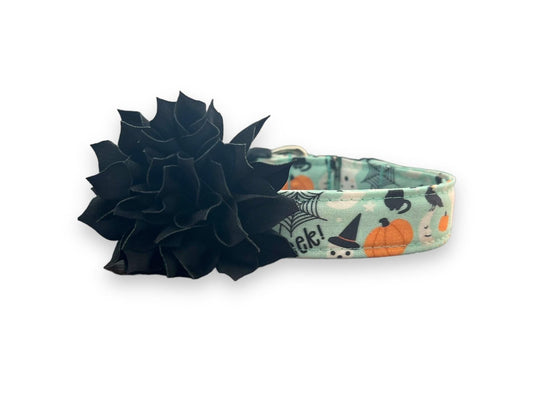 Halloween-themed dog collar with black flower accessory on a white background