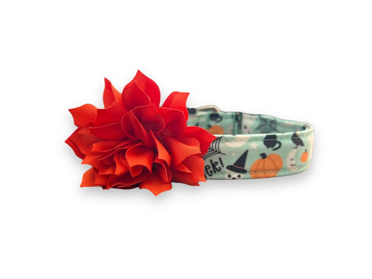 Halloween-themed dog collar with black flower accessory on a white background