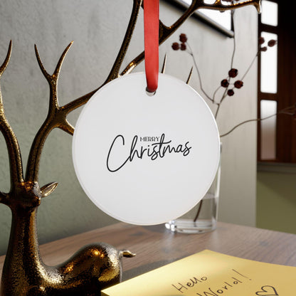 Round white ornament with 'Merry Christmas' text hanging on a branch with a gold deer decoration.