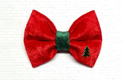 Red and green velvet dog bow tie with a soft, plush texture, displayed on a white background. The festive bow tie features rich holiday colors and a Christmas tree charm. 