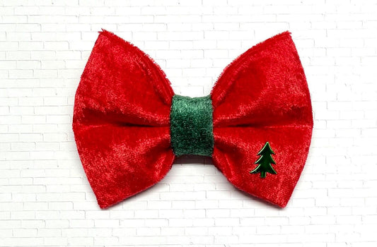 Red and green velvet dog bow tie with a soft, plush texture, displayed on a white background. The festive bow tie features rich holiday colors and a Christmas tree charm. 