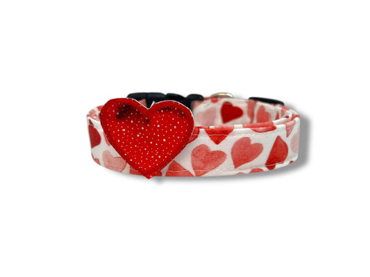 Dog collar with red heart design on a white background with speckled red heart embellishment 