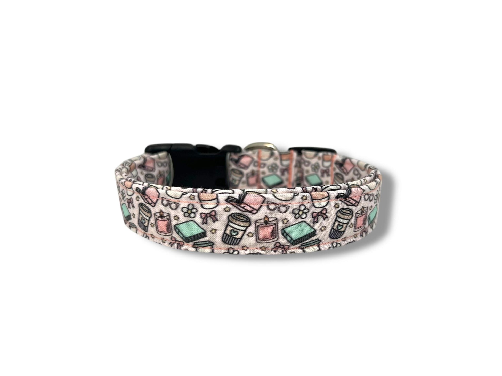 Pale pink dog collar with whimsical illustrations of books, coffee cups, candles, daisies, bows, and glasses.