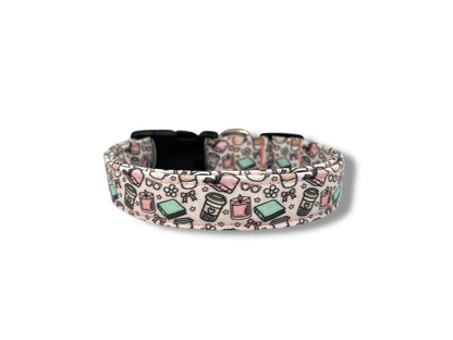 Pale pink dog collar with whimsical illustrations of books, coffee cups, candles, daisies, bows, and glasses.
