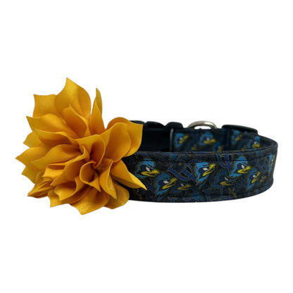 Navy blue dog collar featuring the University of Delaware UD logo and Blue Hens graphics with yellow gold dog collar flower, laid flat on a white background.