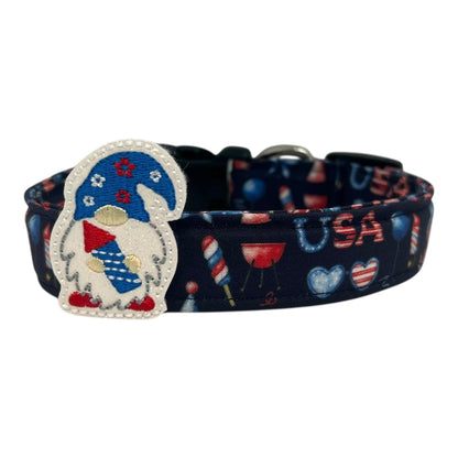 Navy blue 4th of July dog collar decorated with red, white, and blue icons like popsicles, BBQ grills, fireworks, and balloons, featuring a whimsical gnome holding a firecracker embellishment.