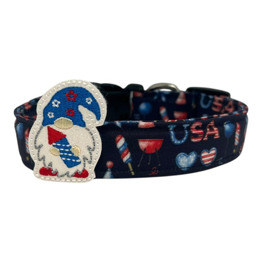 Navy blue 4th of July dog collar decorated with red, white, and blue icons like popsicles, BBQ grills, fireworks, and balloons, featuring a whimsical gnome holding a firecracker embellishment.