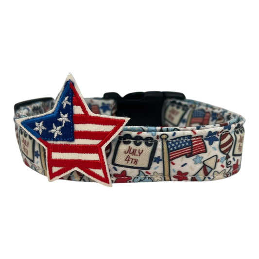 Light-colored 4th of July dog collar with festive icons including American flags, fireworks, balloons, stars, and “July 4th” signs, featuring a bold red, white, and blue embroidered star embellishment.