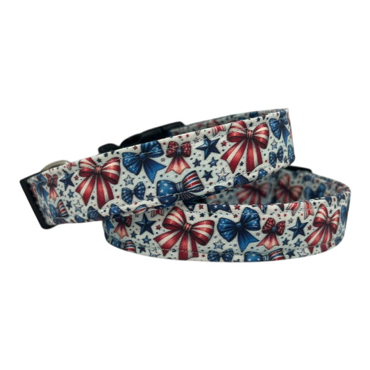 Patriotic dog collar with red, white, and blue bows and stars on a light background.