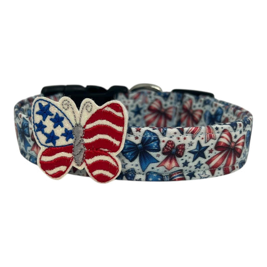 Patriotic dog collar with red, white, and blue coquette bows and stars, featuring a removable embroidered butterfly embellishment styled like the American flag.