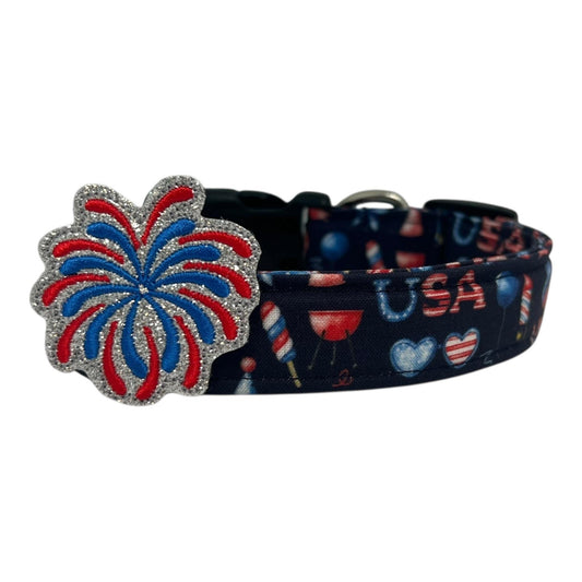 Navy blue 4th of July dog collar decorated with red, white, and blue icons like popsicles, BBQ grills, balloons, and hearts, topped with a glittery red and blue firework embellishment edged in silver.