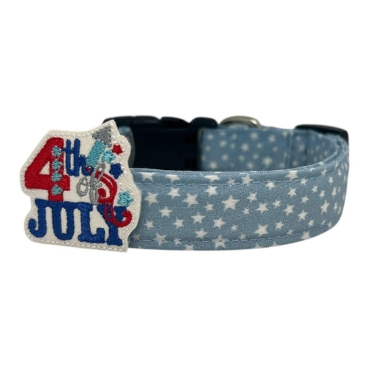 Light blue chambray dog collar with scattered white stars, paired with a removable 4th of July firecracker embellishment in red, white, and blue.