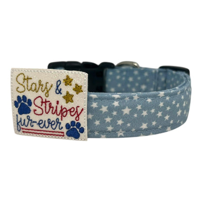 Light blue chambray dog collar with scattered white stars, paired with a removable red, white, and blue “Stars & Stripes Fur-ever” embellishment.