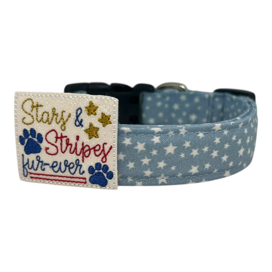 Light blue chambray dog collar with scattered white stars, paired with a removable red, white, and blue “Stars & Stripes Fur-ever” embellishment.