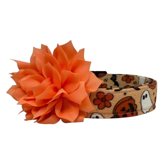 Halloween-themed headband with an orange flower on a white background