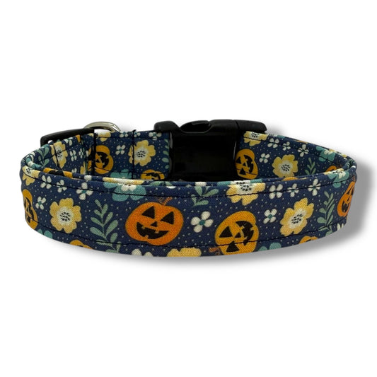 Halloween dog collar with jack-o’-lanterns and floral details on a navy blue background for festive fall style.