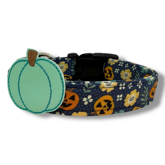 Halloween dog collar with jack-o’-lanterns, floral accents, and removable aqua pumpkin embellishment on a navy blue background.
