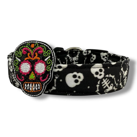 Halloween dog collar with skeletons and skulls on a black background, includes removable shimmery sugar skull embellishment.
