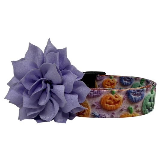 Halloween dog collar with rainbow jack-o’-lanterns in orange, green, purple, and blue with light lavender removable dog collar flower. 