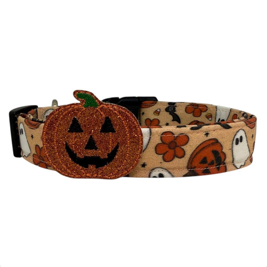 Tan Halloween dog collar with ghosts, jack-o’-lanterns, bats, candy corn, orange flowers, and a detachable shimmery pumpkin embellishment.