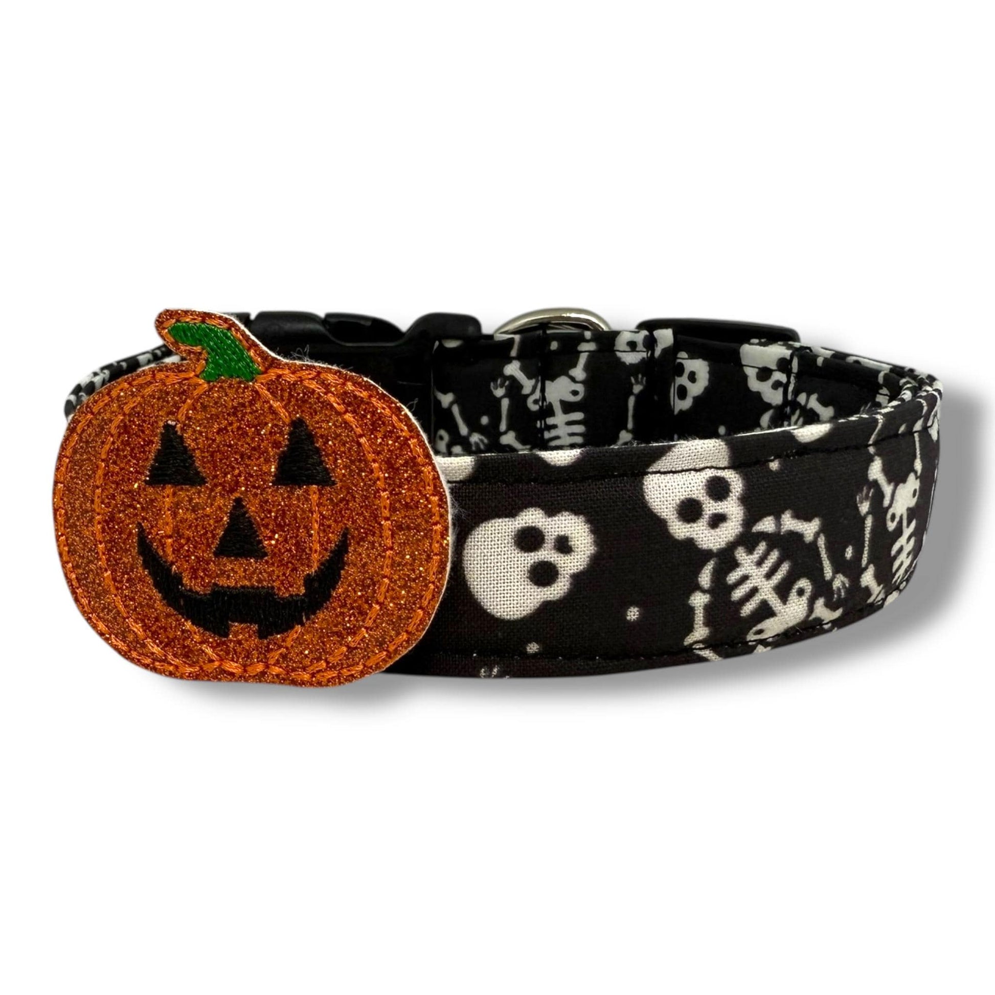 Halloween dog collar with skeletons and skulls on a black background, includes removable shimmery pumpkin embellishment.