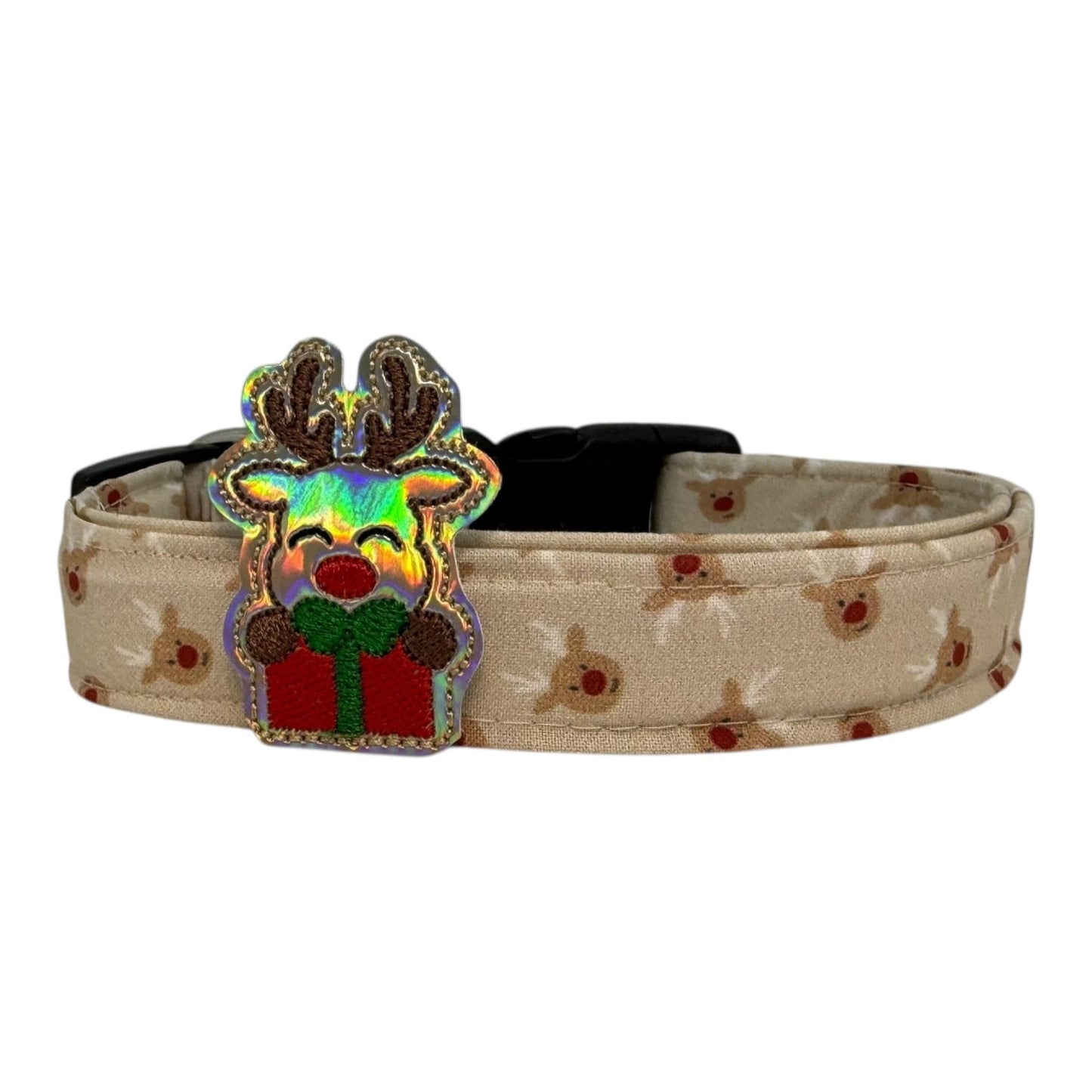 Beige dog collar with small red-nose reindeer faces and a removable iridescent reindeer embellishment, adjustable with black buckle and metal D-ring.