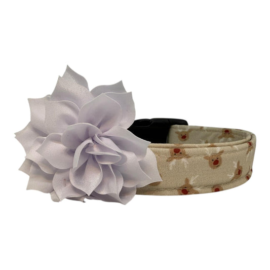 Beige dog collar with small red-nose reindeer faces and a removable flower attachment, adjustable with black buckle and metal D-ring.