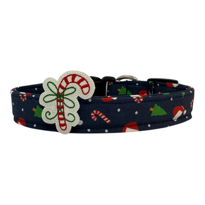 Navy cotton dog collar printed with small Christmas icons, featuring a removable candy cane embellishment. The collar has a side-release buckle and metal D-ring, handmade and adjustable in multiple sizes.