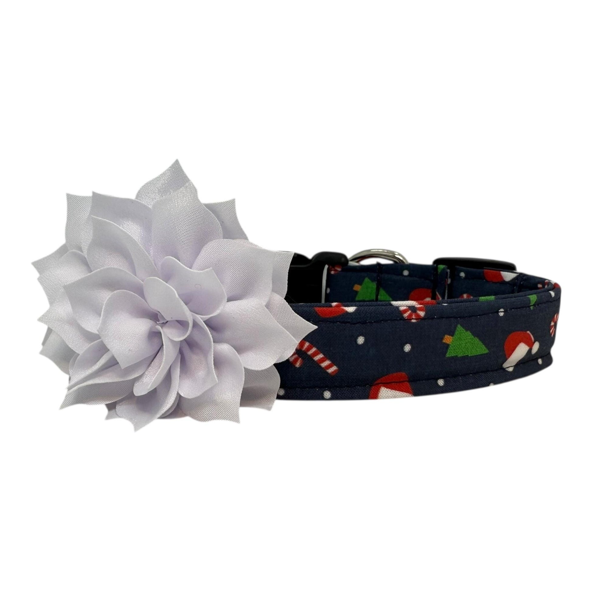 Navy cotton dog collar printed with small Christmas icons, featuring a removable white dog collar flower, side-release buckle and metal D-ring, handmade and adjustable in multiple sizes