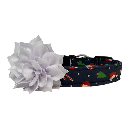Navy cotton dog collar printed with small Christmas icons, featuring a removable white dog collar flower, side-release buckle and metal D-ring, handmade and adjustable in multiple sizes