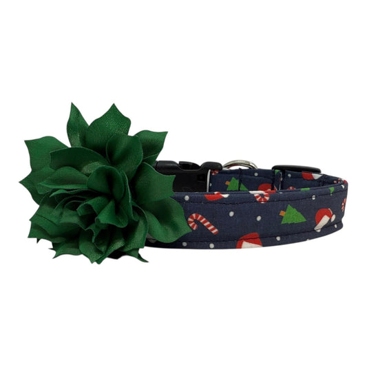 Navy cotton dog collar printed with small Christmas icons, featuring a removable emerald green dog collar flower, side-release buckle and metal D-ring, handmade and adjustable in multiple sizes