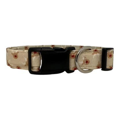 Beige dog collar with small red-nose reindeer faces, adjustable with black buckle and metal D-ring