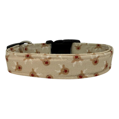 Beige dog collar with small red-nose reindeer faces and a removable flower attachment, adjustable with black buckle and metal D-ring.